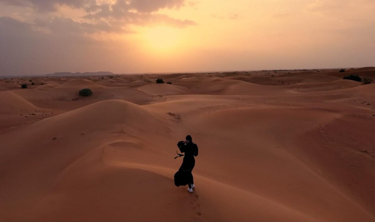 Voyageuse marchant sur les dunes au coucher du soleil